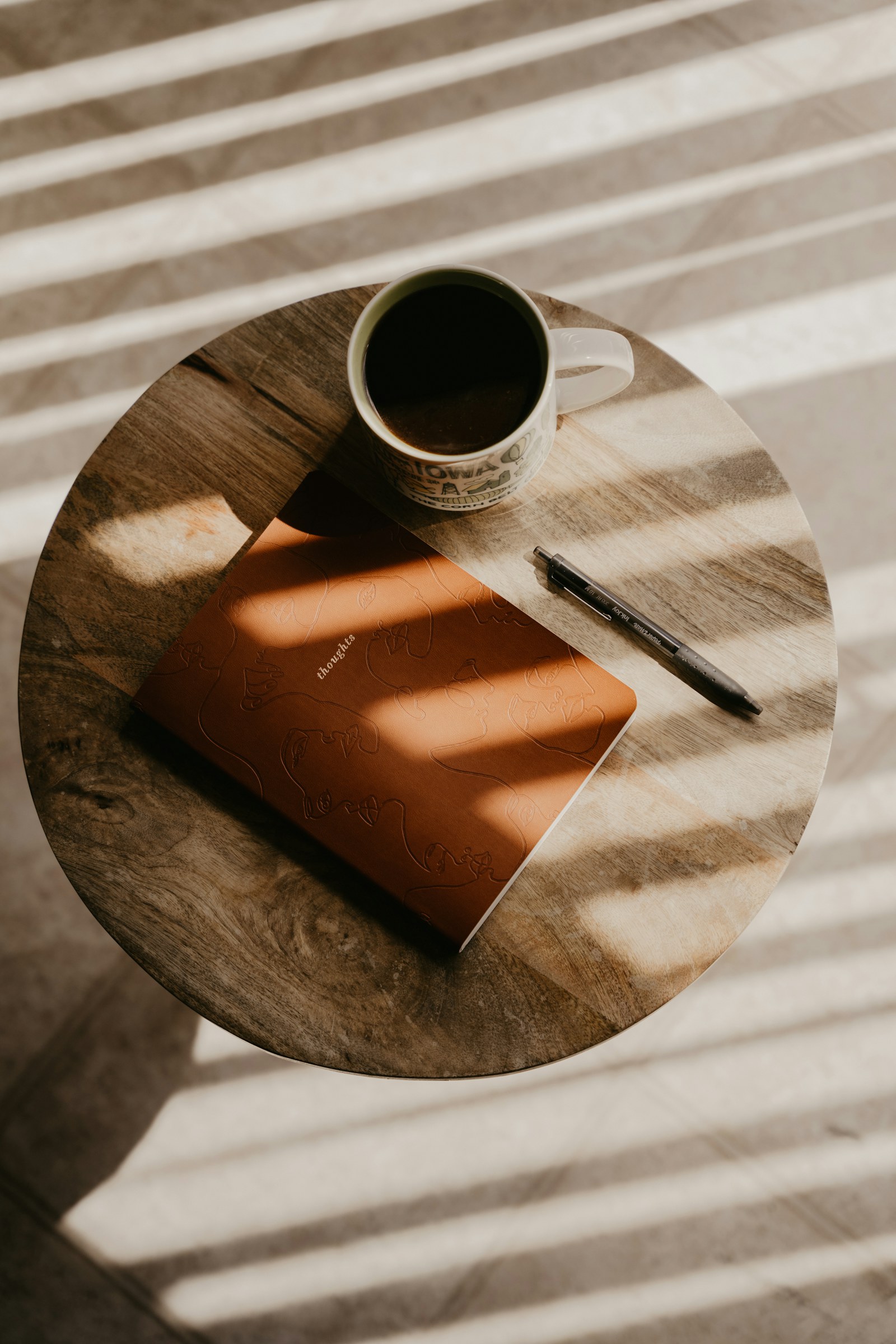 A journal and coffee resting in sunlight
